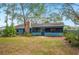 Charming back exterior with brick chimney, screened lanai, and well-maintained landscaping at 15 Tera Ln, Winter Haven, FL 33880