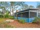 Exterior view of the screened-in porch, brick chimney, and beautiful flower beds around the home at 15 Tera Ln, Winter Haven, FL 33880