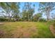 Spacious, level backyard featuring a well-manicured lawn and mature landscaping at 15 Tera Ln, Winter Haven, FL 33880