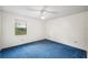 Carpeted bedroom featuring a window with views and a ceiling fan at 15 Tera Ln, Winter Haven, FL 33880