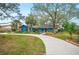 View of the home from across the front yard, showing the long, curved driveway and landscaping at 15 Tera Ln, Winter Haven, FL 33880