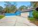 View of the side of the home with the garage, driveway and light blue exterior at 15 Tera Ln, Winter Haven, FL 33880