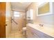 Bathroom featuring tile shower with safety bar and a vanity with white cabinets at 1548 Churchill Ct, Lakeland, FL 33801