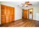 Bedroom with ceiling fan, laminate floors, and a double door closet with an ensuite bathroom at 1548 Churchill Ct, Lakeland, FL 33801