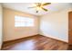 Comfortable bedroom with hardwood floors, a ceiling fan, and natural light at 1548 Churchill Ct, Lakeland, FL 33801