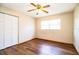 Bright bedroom features wood laminate flooring, a ceiling fan, and a double door closet at 1548 Churchill Ct, Lakeland, FL 33801