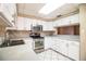 Bright kitchen featuring stainless steel appliances, white cabinets, and tile flooring at 1548 Churchill Ct, Lakeland, FL 33801