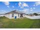 View of the backyard featuring a lawn and a white privacy fence at 1706 Tressel Ct, Winter Haven, FL 33881