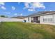 A view of the home's backyard, showing the patio, lawn, and privacy fence at 1706 Tressel Ct, Winter Haven, FL 33881