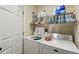 Bright laundry room with modern washer and dryer and built-in shelving at 1706 Tressel Ct, Winter Haven, FL 33881