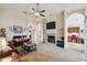 Cozy living room with a fireplace, ceiling fan, and neutral color scheme. The open layout leads to the kitchen at 1706 Tressel Ct, Winter Haven, FL 33881