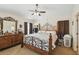 Main bedroom featuring a decorative metal bed frame, ceiling fan, and dresser. Natural light fills the room at 1706 Tressel Ct, Winter Haven, FL 33881