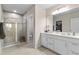 Modern bathroom featuring a glass-enclosed shower, double vanity, and neutral tile at 2027 Airedale Way, Lake Alfred, FL 33850