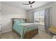 Inviting bedroom featuring a cozy bed, ceiling fan, and large window for natural light at 2027 Airedale Way, Lake Alfred, FL 33850