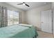 Bright bedroom with ceiling fan, neutral walls, and a large window with views of the outdoors at 2027 Airedale Way, Lake Alfred, FL 33850