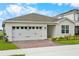 Well-maintained single-story home featuring a two car garage, manicured lawn and beautiful landscaping at 2027 Airedale Way, Lake Alfred, FL 33850