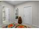 Bright hallway featuring neutral walls, colorful rug, and doorways leading to bedroom and bathroom at 2027 Airedale Way, Lake Alfred, FL 33850