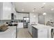 Well-lit kitchen featuring an island, stainless steel appliances, white cabinetry and tile flooring at 2027 Airedale Way, Lake Alfred, FL 33850