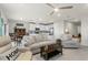 Open-concept living room flows into the dining area and kitchen, featuring comfortable seating and a ceiling fan at 2027 Airedale Way, Lake Alfred, FL 33850