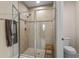 Modern bathroom showcasing a glass-enclosed shower with tiled walls and a convenient built-in wooden bench at 2027 Airedale Way, Lake Alfred, FL 33850