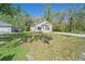 Charming single-story home with a well-manicured lawn and a detached garage on a sunny day at 2161 Maple Hill Ct, Lakeland, FL 33811