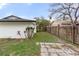 Side yard featuring a wooden fence, some plants, and a concrete tiled area at 2326 Eastmeadows Rd, Lakeland, FL 33812