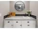 Bar area featuring white cabinetry, dark backsplash, stainless steel sink, and a round mirror at 2326 Eastmeadows Rd, Lakeland, FL 33812