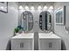 Gray bathroom with dual sink vanities, oval mirrors, and modern lighting fixtures at 2326 Eastmeadows Rd, Lakeland, FL 33812