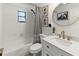 Stylish bathroom features a shower-tub combo, white vanity and a gold-trimmed round mirror at 2326 Eastmeadows Rd, Lakeland, FL 33812