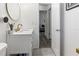 Tastefully-designed bathroom featuring a white vanity, gold hardware, a round mirror, and tile flooring at 2326 Eastmeadows Rd, Lakeland, FL 33812