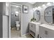 Bathroom featuring double sinks, modern fixtures, tile flooring, and ample lighting for a refreshing experience at 2326 Eastmeadows Rd, Lakeland, FL 33812