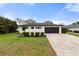 Charming single-story home with a black garage door, vibrant green lawn, and manicured shrubbery at 2326 Eastmeadows Rd, Lakeland, FL 33812