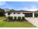 Charming single-story home with a black garage door, vibrant green lawn, and manicured shrubbery at 2326 Eastmeadows Rd, Lakeland, FL 33812