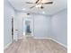 Bright bedroom with wood-look flooring, a ceiling fan and an open doorway to another room at 2521 Coral Way, Lakeland, FL 33801