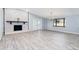 Bright living room with stone fireplace, modern lighting fixture and laminate flooring providing stylish focal points at 2521 Coral Way, Lakeland, FL 33801