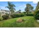 A lush green backyard with mature trees and privacy hedging creates a serene outdoor space at 2616 Fairmount Ave, Lakeland, FL 33803