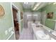 Well-lit bathroom featuring a double sink vanity, a glass enclosed shower, and neutral tiling at 2616 Fairmount Ave, Lakeland, FL 33803