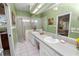 Bathroom featuring a double sink vanity, glass enclosed shower, and neutral tiling at 2616 Fairmount Ave, Lakeland, FL 33803