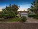 Charming single-story home featuring a stucco exterior, well-manicured lawn, and an attached two-car garage at dusk at 2616 Fairmount Ave, Lakeland, FL 33803