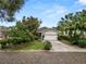 Charming front exterior with a spacious driveway, mature trees, and well-manicured lawn at 2616 Fairmount Ave, Lakeland, FL 33803