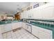 Bright kitchen features white cabinetry, tile floors, and green countertops that connect to the living room at 2616 Fairmount Ave, Lakeland, FL 33803