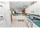 Bright kitchen features white cabinetry, tile floors, and green countertops that connect to the living room at 2616 Fairmount Ave, Lakeland, FL 33803