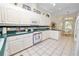 Bright kitchen features white cabinetry, tile floors, and a breakfast nook with natural light at 2616 Fairmount Ave, Lakeland, FL 33803