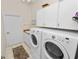 This laundry room features tile floors, white cabinets, and a front load washer and dryer at 2616 Fairmount Ave, Lakeland, FL 33803