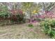 This backyard offers a colorful array of flowers among mature trees, enhancing the outdoor living experience at 2638 Ralph Rd, Lakeland, FL 33801