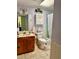 Bathroom with wooden vanity, toilet, and shower/tub combination with green tile at 3023 Maplewood Ave, Lakeland, FL 33803