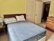 Bedroom with blue bedspread, light-colored walls, and doorway into an adjoining room at 3023 Maplewood Ave, Lakeland, FL 33803