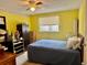 Bright bedroom with yellow walls, black storage units, and natural light from the window at 3023 Maplewood Ave, Lakeland, FL 33803