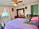 Bedroom features a large mirror dresser, ceiling fan, and comfortable purple quilted bedspread at 3023 Maplewood Ave, Lakeland, FL 33803