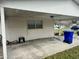 Carport area with concrete floor, exterior lighting, and residential waste container at 3023 Maplewood Ave, Lakeland, FL 33803